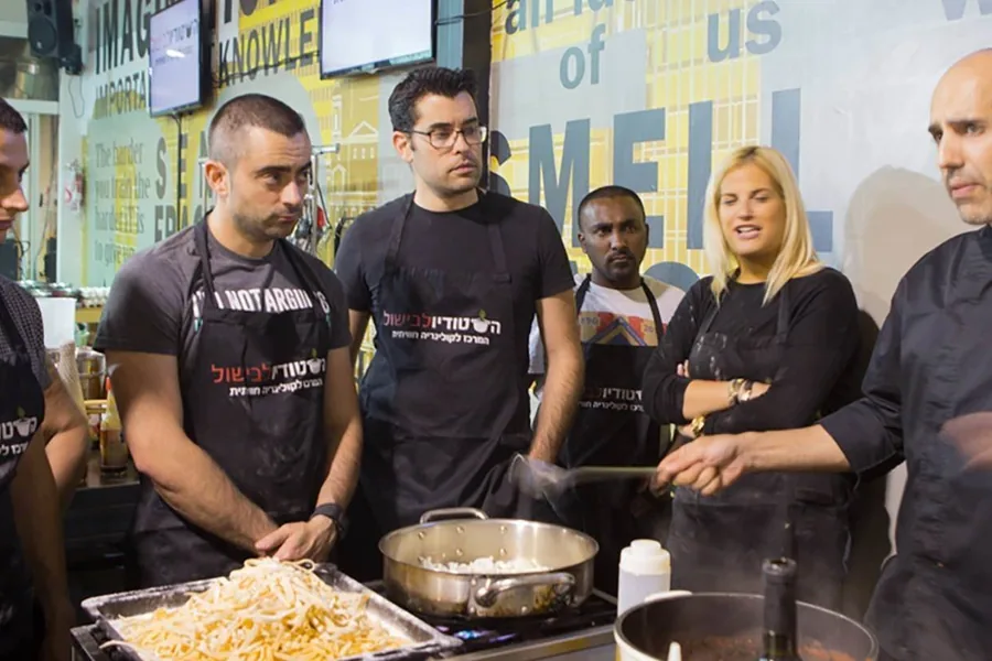A group around the chef at the stove line