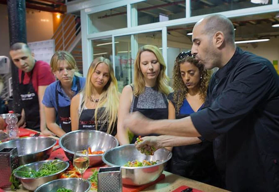 A chef demonstrating to a group of participants