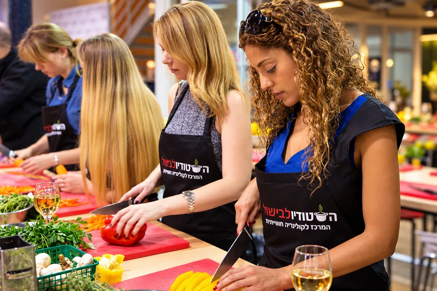 חותכות ירקות יחד בעמדה, עם כוס יין