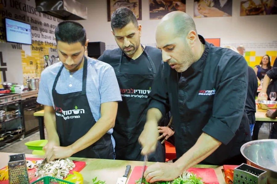 Two participants chopping vegetables side by side