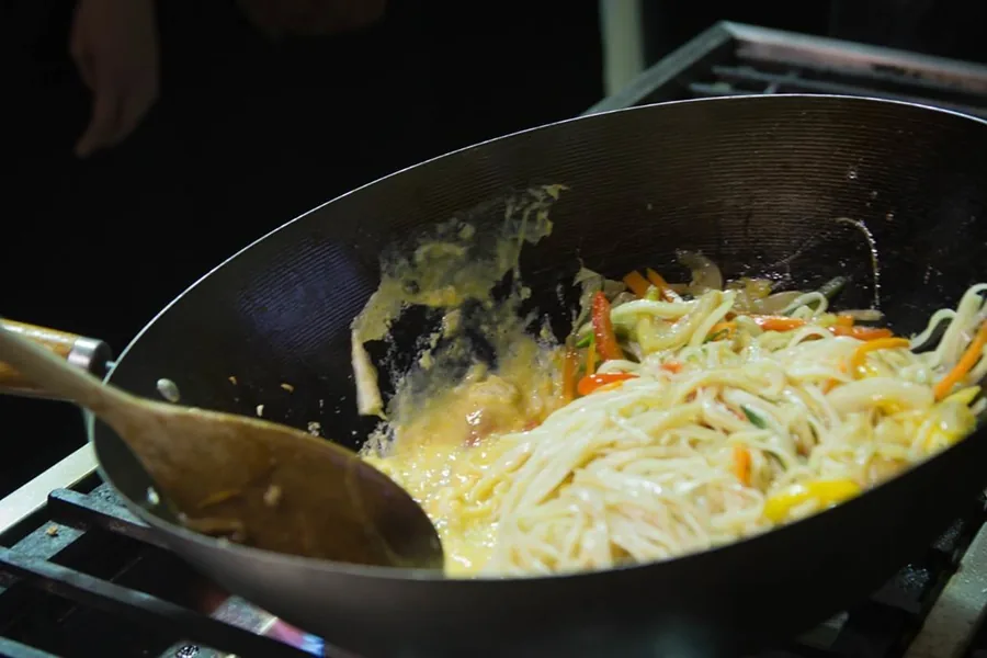 A wok over a high flame, mid stir-fry